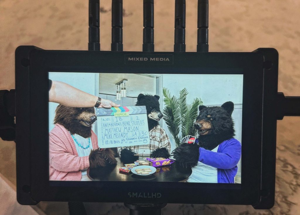 Production monitor showing three bear characters and a clapperboard on the Dare Foods Bear Paws and UNO set.