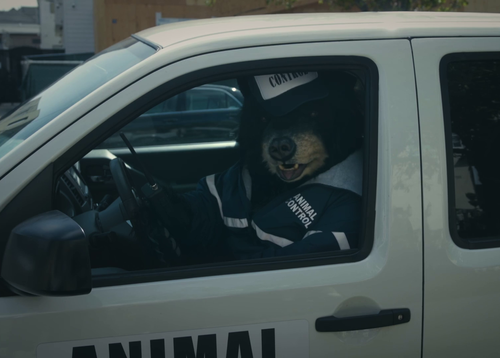 Person Control Bear seated at the wheel of a van in Exit, Pursued by a Bear.